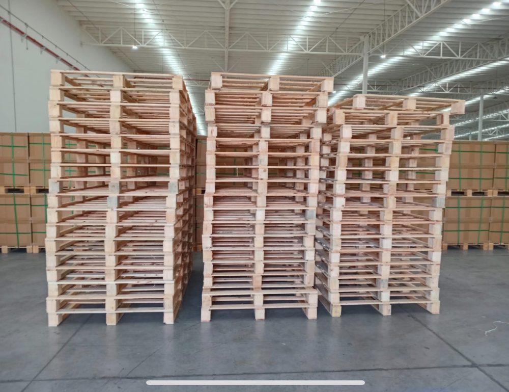 Tarimas tacón nuevas apiladas en almacén